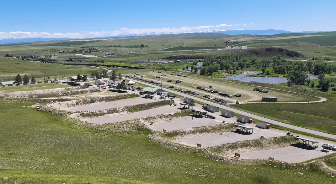 A large field filled with numerous trucks parked in various positions across the grassy area.